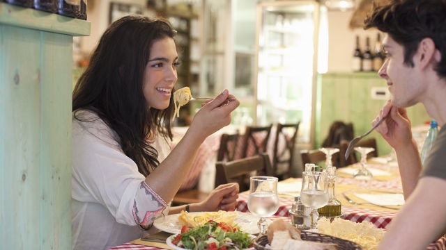 אישה נהנית מאוכל במסעדה ללא פצעים בלשון