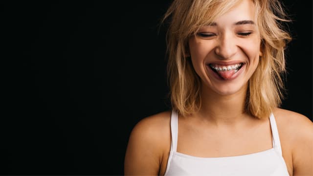 אישה מחייכת עם גשר בשיניים