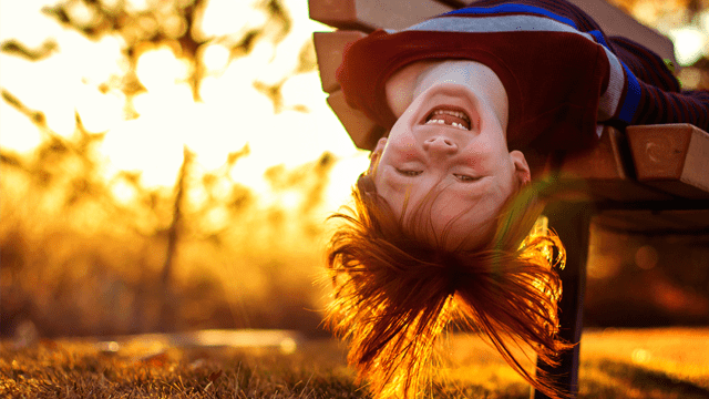 ילד תלוי הפוך להמחשה של סיבות לחריקת שיניים ילדים