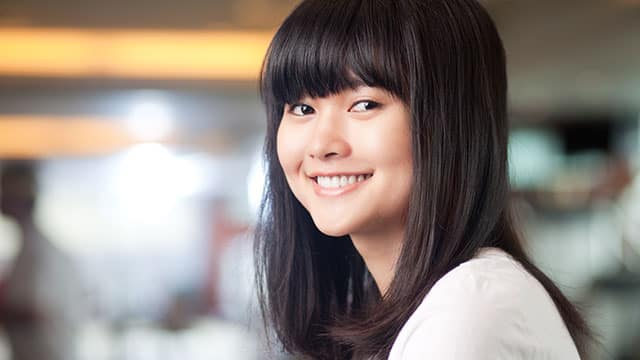 נערה צעירה מחייכת בתוך הבית.