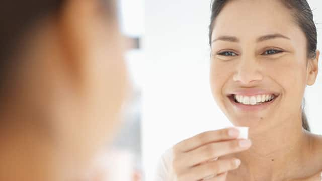 Close-up of young woman rinsing her mouth with mouthwash