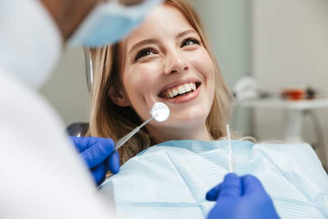 רופא שיניים מסביר למטופלת על דלקת אחרי עקירה